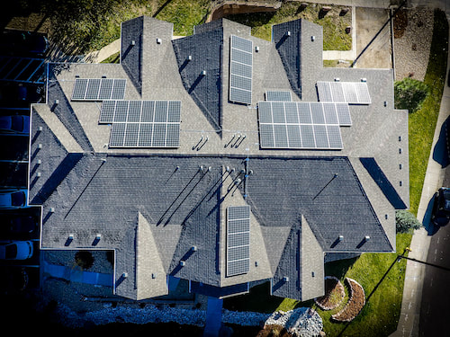 Aerial drone photo directly above a very large American River home with a gray composite roof.
