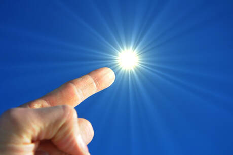 A finger pointing in the sky toward the sun as if to signify a bright idea such as free electricity.